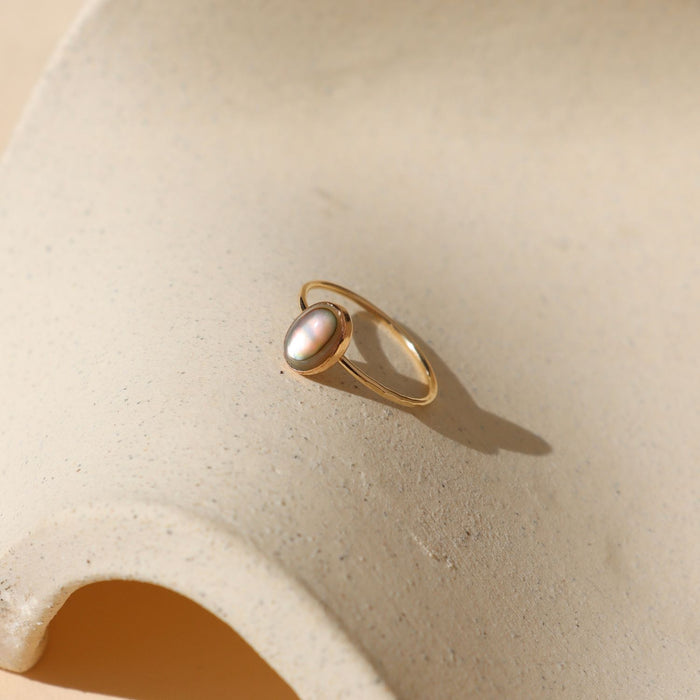 14k gold fill  ring with handset abalone stone on a light dish
