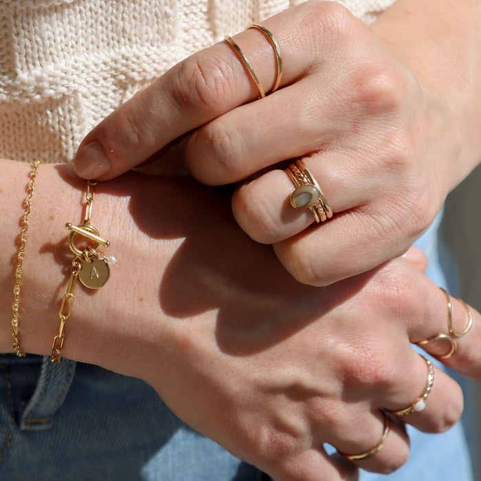 model wearing 14k gold fill rings with abalone stone and texture