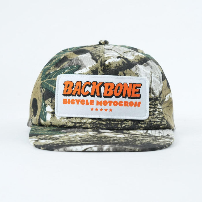 A Backbone 5 Star Snapback Hat in camouflage, with a front patch reading "BACKBONE BICYCLE MOTOCROSS" in bold orange and white lettering, shown on a plain white background.