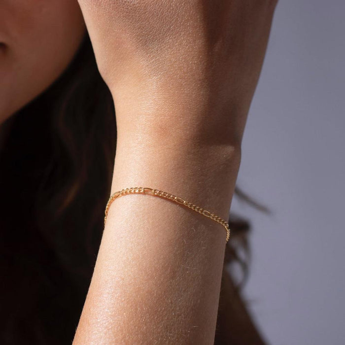 Model wearing 14k gold fill figaro chain bracelet