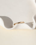 smooth 14k solid gold band ring on a white dish
