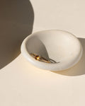 14k gold fill ring with round citrine stone on a light bowl
