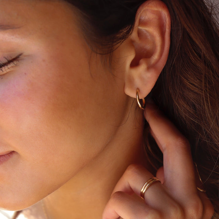 model wearing 14k solid gold classic hoop earrings