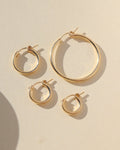 gold fill mini classic hoop, gold fill small classic hoop, gold fill medium classic hoop, gold fill large classic hoop laid in the sun