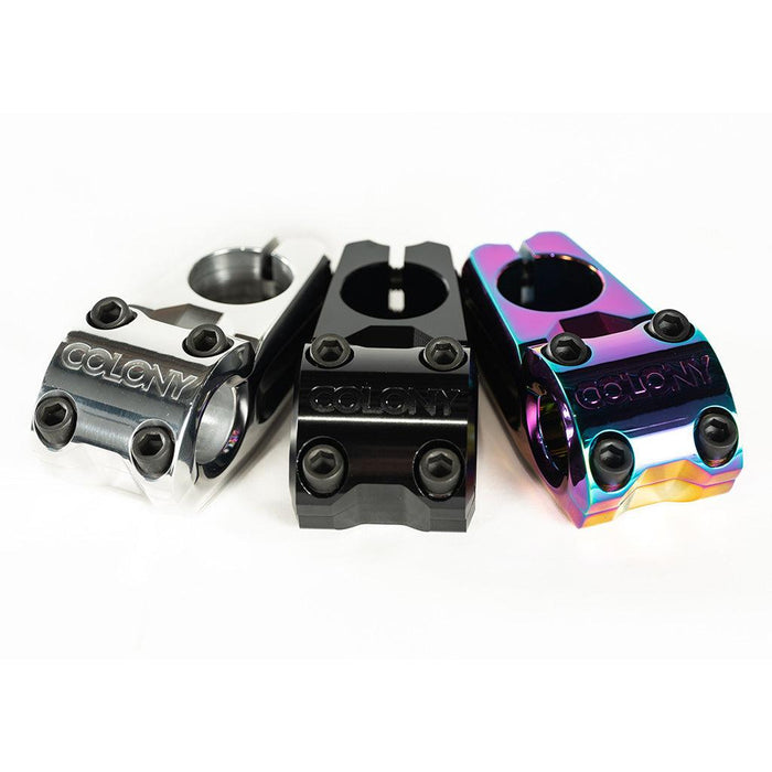 Three BMX bike stems—including the low-rise Colony Variant 52mm BMX Stem (22.2mm Clamp)—are displayed side by side in silver, black, and rainbow finishes, each with the “COLONY” logo engraved on the front.