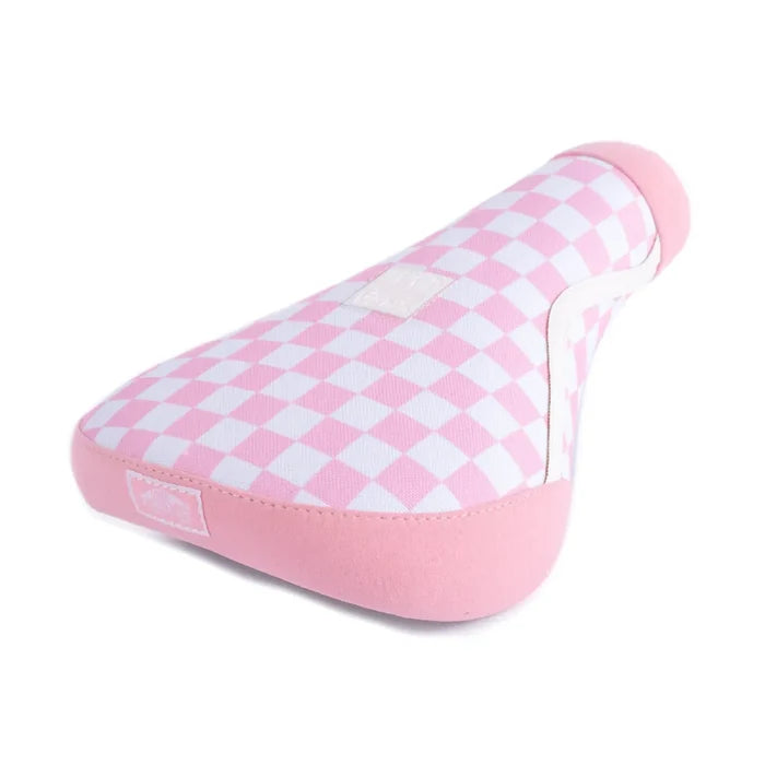 The Cult Vans Old Skool Checker Pivotal Seat features a pink and white checkered design with a soft, padded construction and a light pink border, inspired by the iconic BMX seat style.