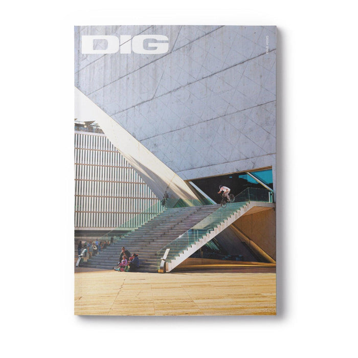 A cyclist rides up an outdoor staircase next to a modern building as people sit on the steps. The DIG Book Issue 2025 logo appears at the top.
