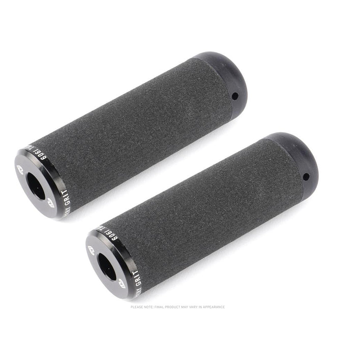 Two black cylindrical bicycle handlebar grips with a textured surface and metal end caps on a white background—ideal to pair with Eclat Emery Grit Alloy Flatland Pegs (Pair) for improved BMX control and style.