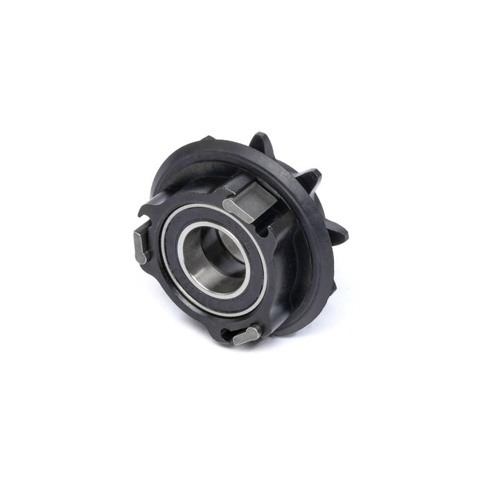 A close-up of the Eclat Shift Hub Driver, a mechanical bearing component with metal and black plastic parts, showing its driver and pawls with springs, photographed on a white background.