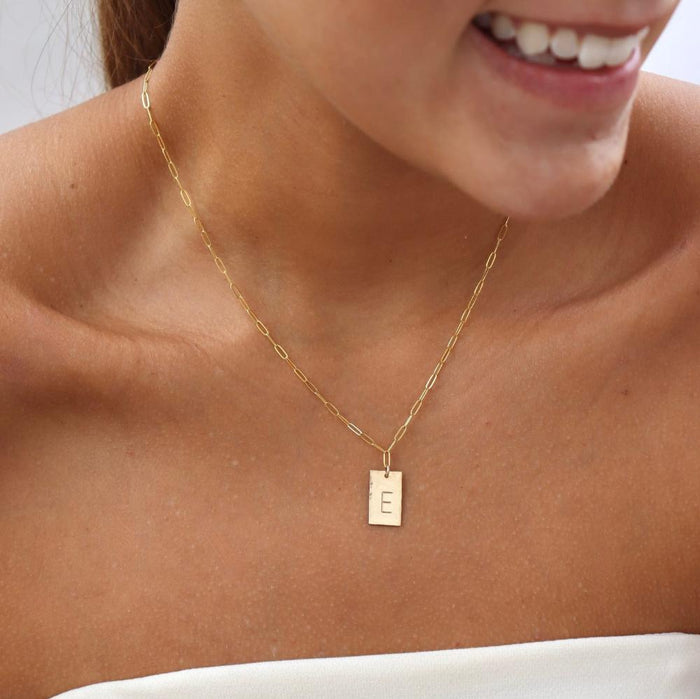 model wearing 14k gold fill hand stamped pendant on a paperclip chain necklace