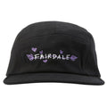 The Fairdale Nora V Camper Cap is a black five-panel hat featuring custom Nora bike-inspired artwork with "FAIRDALE" embroidered in white and purple, surrounded by small purple hearts and leaves.