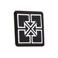 The Fit Bike Co Key Embroided Patch is a black patch with a white geometric cross and triangle design at the center, finished with a sleek satin border.