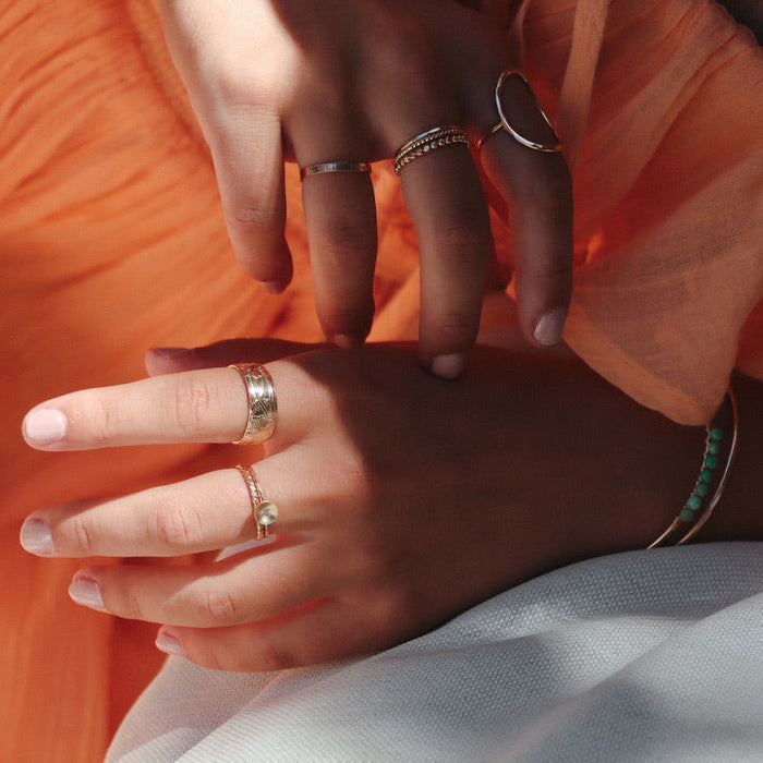 model wearing 14k gold fill textured band ring with delicate band with domed circle and other 14k gold fill rings