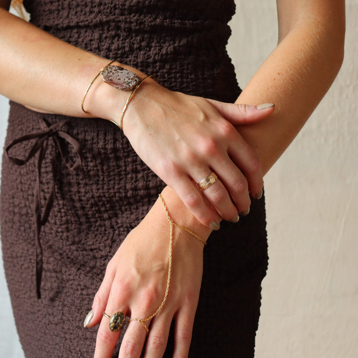 model wearing 14k gold fill textured ring with hand chain and other 14k gold fill jewelry