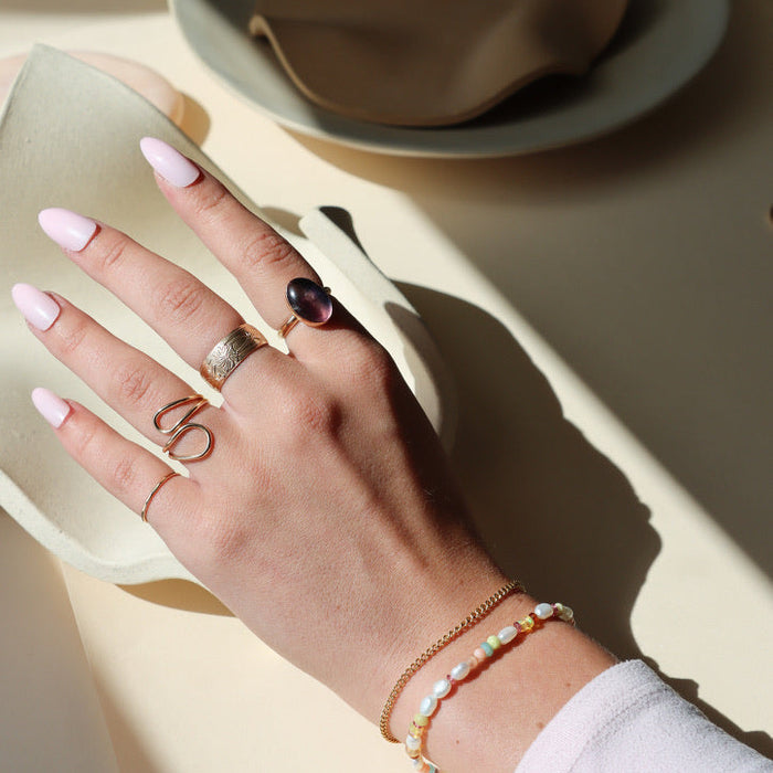 model wearing 14k gold fill rings with fluorite stone paired with a chain bracelet and a beaded bracelet
