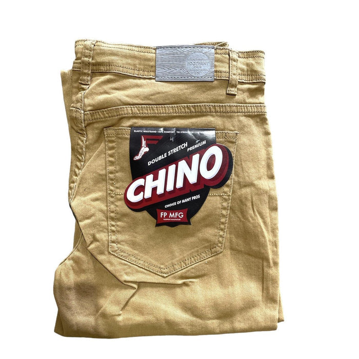 Folded pair of beige chino pants with a label on the back pocket that reads "FP Pants Relaxed Fit Chino Tan" and "FP MFG." These relaxed fitting chino pants offer both comfort and style.