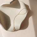 14k gold fill hand chain with pearls on a light dish