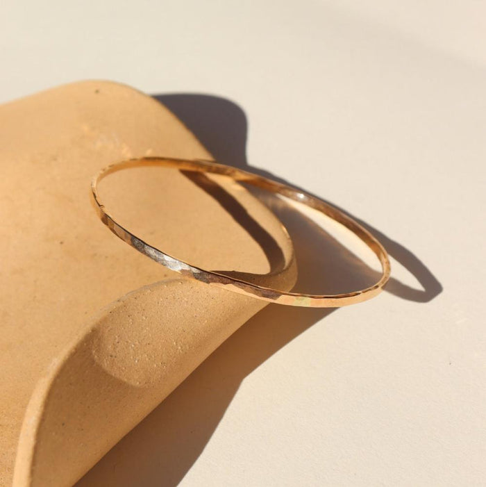 14k gold fill hammered bangle in the sunlight