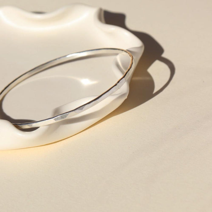 Sterling Silver Hammered Bangle on a light dish