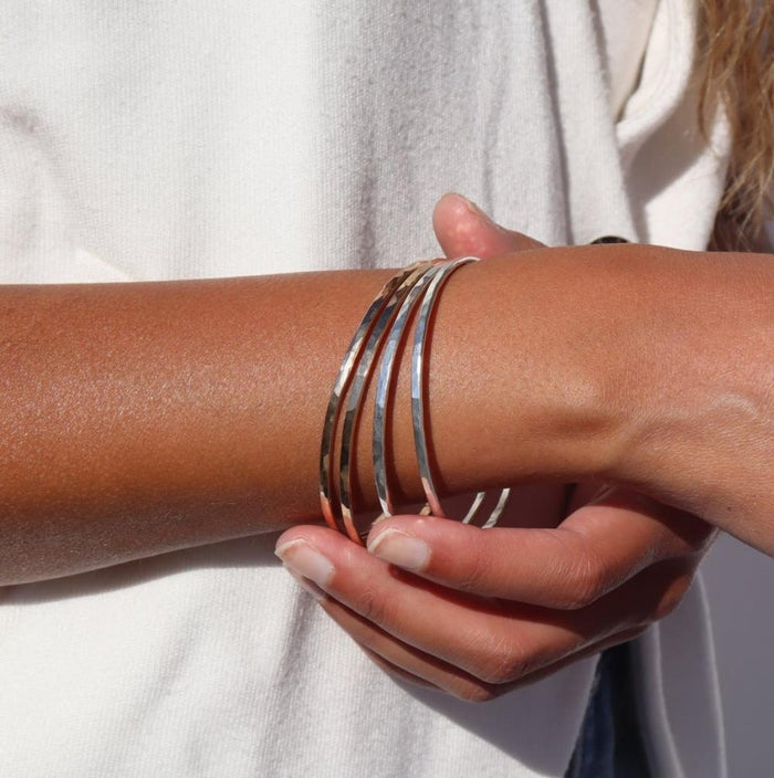 model wearing sterling silver hammered bangles