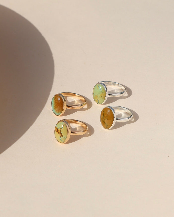 sterling silver and 14k gold fill rings with oval turquoise gemstones in the sunlight