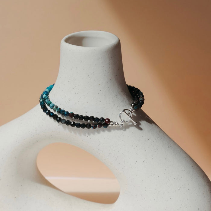 beaded chrysocolla bracelet with toggle clasp on a light vase