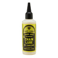 A bottle of Juice Lubes Chain Juice (Dry Chain Lube) with a black nozzle and "professional grade" yellow and black label; this biodegradable lube keeps your bike chain smooth and clean in dry conditions.
