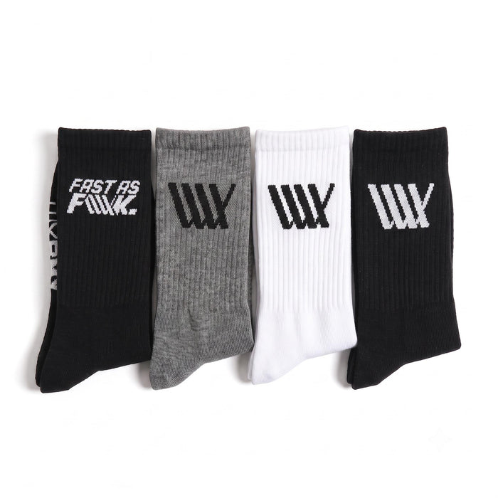 Four pairs of LUXBMX Crew Socks (4 Pack Mix)—in black, gray, white, and black—are displayed side by side, each showcasing striking graphic logos or text on the cuffs. Crafted for both comfort and durability, these crew socks are perfect for BMX riders who want a blend of style and performance.