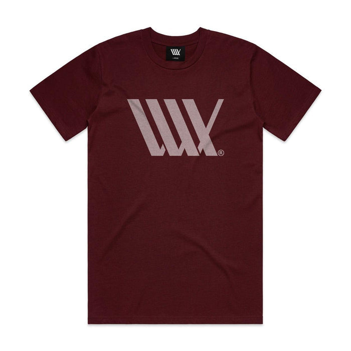 The LUXBMX Flag Tee Maroon is a heavyweight t-shirt with a light gray geometric logo on the chest, featuring overlapping lines forming an angular design.