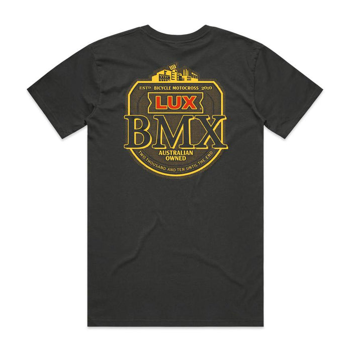 The LUXBMX Gold Tee Coal is a black classic crew t-shirt featuring a bold yellow and red "LUX BMX" logo on the front and “Australian Owned” text on the back, complete with cityscape details that celebrate this Brisbane icon and showcase its “Bicycle Motocross 2010” heritage.