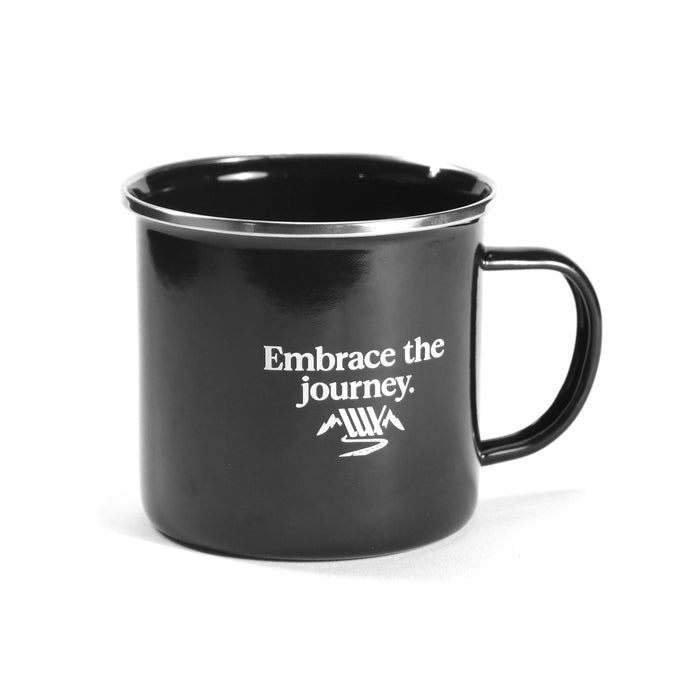 A black enamel mug with a handle, “Embrace the journey.” text, and a small mountain graphic—a perfect match for the LUXBMX Journey Explorer Bundle.