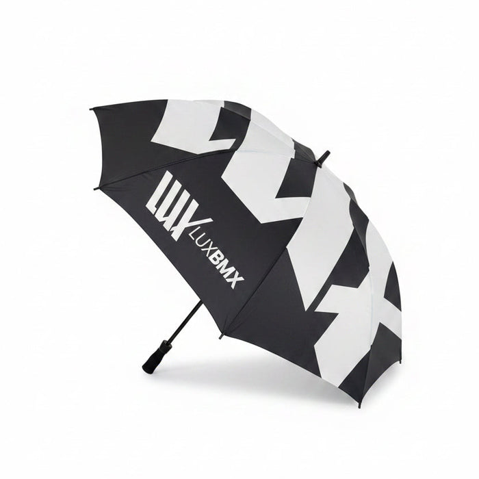 The LUXBMX Race Track Umbrella is black with bold white geometric patterns, double-stitched seams, and "LUXBMX" printed on one panel, shown against a plain white background.