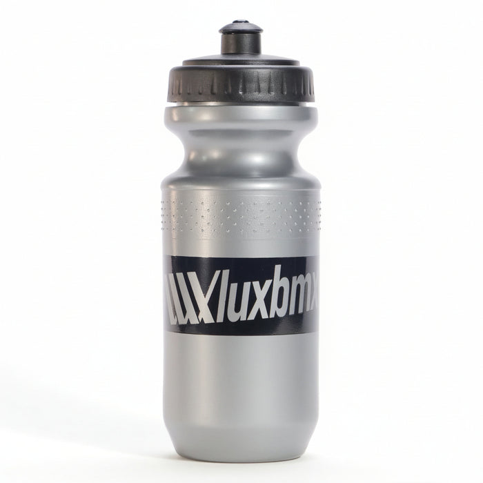 The LUXBMX Squirt Water Bottle 500ml is silver, made from BPA-free plastic, and features a black screw cap and spout. Bold "Luxbmx" lettering stands out on its side.