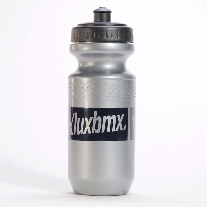 The LUXBMX Squirt Water Bottle 500ml in silver is made from BPA-free plastic, features a black screw-on lid and "Kluxbmx" text on the front, and stands upright on a white background.
