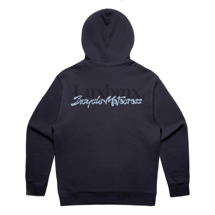 An ink blue LUXBMX Times Neue Hoodie lies flat, displaying the back with "Luxbmx" and "Bicycle Motocross" in large stylized lettering. This heavyweight pullover fleece is ideal for BMX enthusiasts seeking both comfort and style.