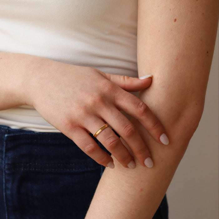 model wearing 14k solid gold textured rings