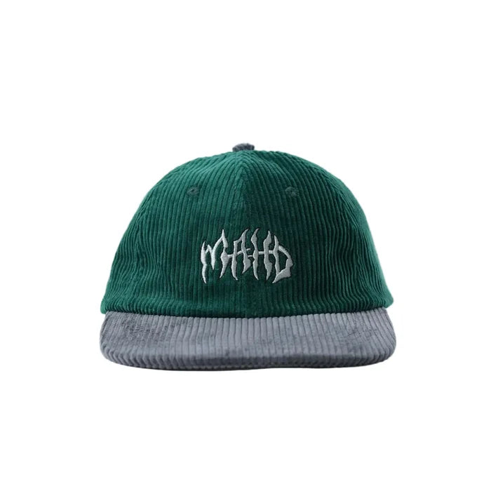 The Mahd Metal Corduroy Hat is a green corduroy baseball cap with a structured crown, gray brim, and white embroidered text on the front, displayed against a white background.