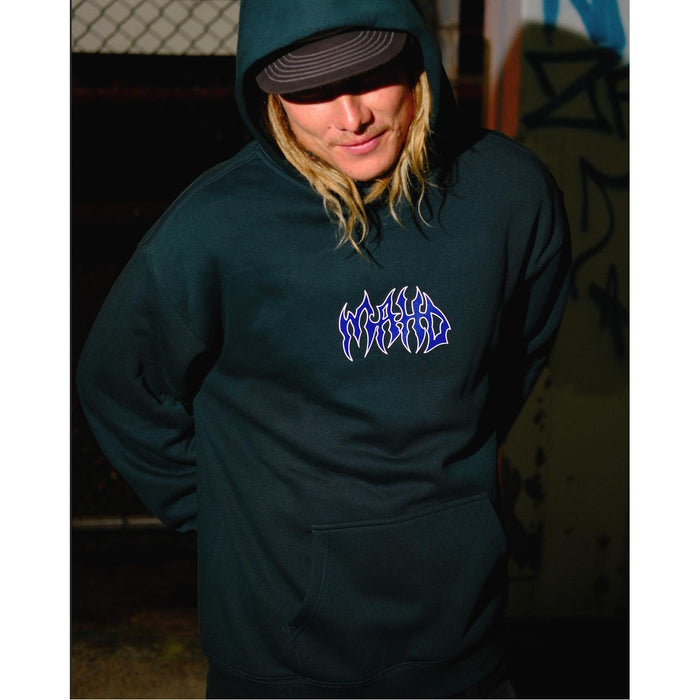 A person wearing the Mahd Metal Hoodie, featuring stylized "WORLD" text on the chest, stands outdoors at night by a chain-link fence with graffiti in the background.