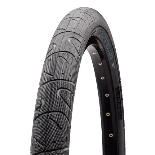 A close-up of the Maxxis Hookworm 24 Inch Tyre highlights its textured tread and visible Maxxis branding on the sidewall, engineered for flat-resistant urban cycling.