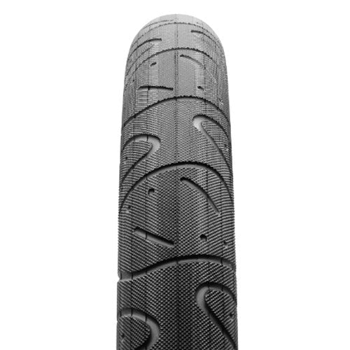 Close-up of a Maxxis Hookworm 24 Inch Tyre in black, showing its textured surface and unique wavy tread pattern, renowned for flat resistance, photographed from above.