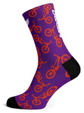 A Meybo Sock Ribbed Crew in purple, featuring orange bicycle patterns and black toe and heel sections—perfect for a recovery ride on the road.