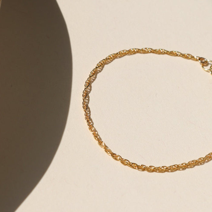 14k gold fill chain bracelet laid on a light background in the sunlight