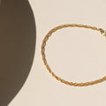 14k gold fill chain bracelet laid on a light background in the sunlight