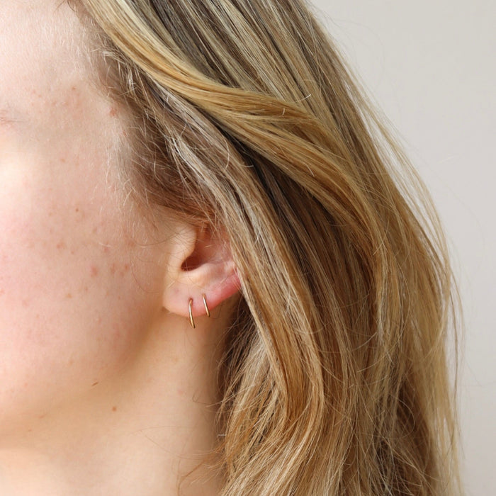 model wearing 14k solid gold twist hoops