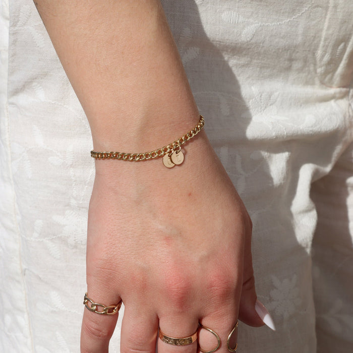 model wearing 14k gold fill curb chain bracelet with 14k gold fill rings