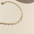 14k gold fill delicate paperclip chain anklet on a light surface