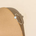 sterling silver bezel ring setting with delicate 4mm opal stone near a dish