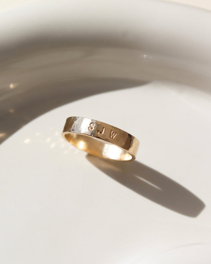 14k gold fill hand stamped cigar band ring on a light dish