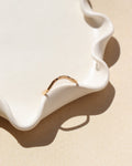 14k gold fill hammered ring with plunge detail on a light dish