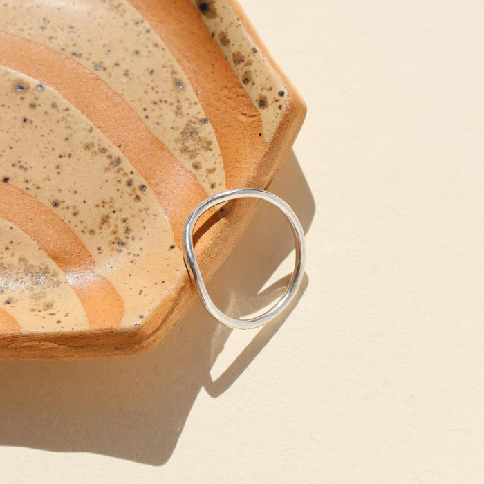 sterling silver ring with plunge detail on a colored dish